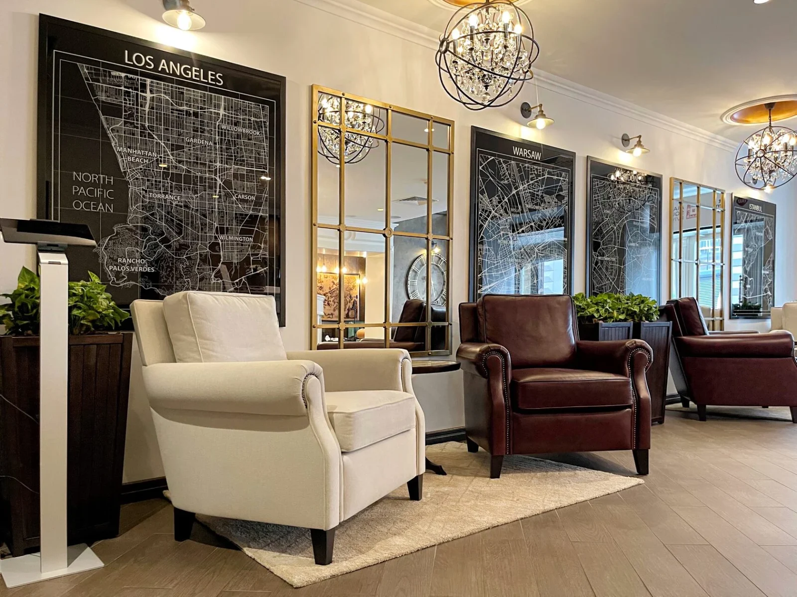 A white armchair and a burgundy leather chair below a Los Angeles map print