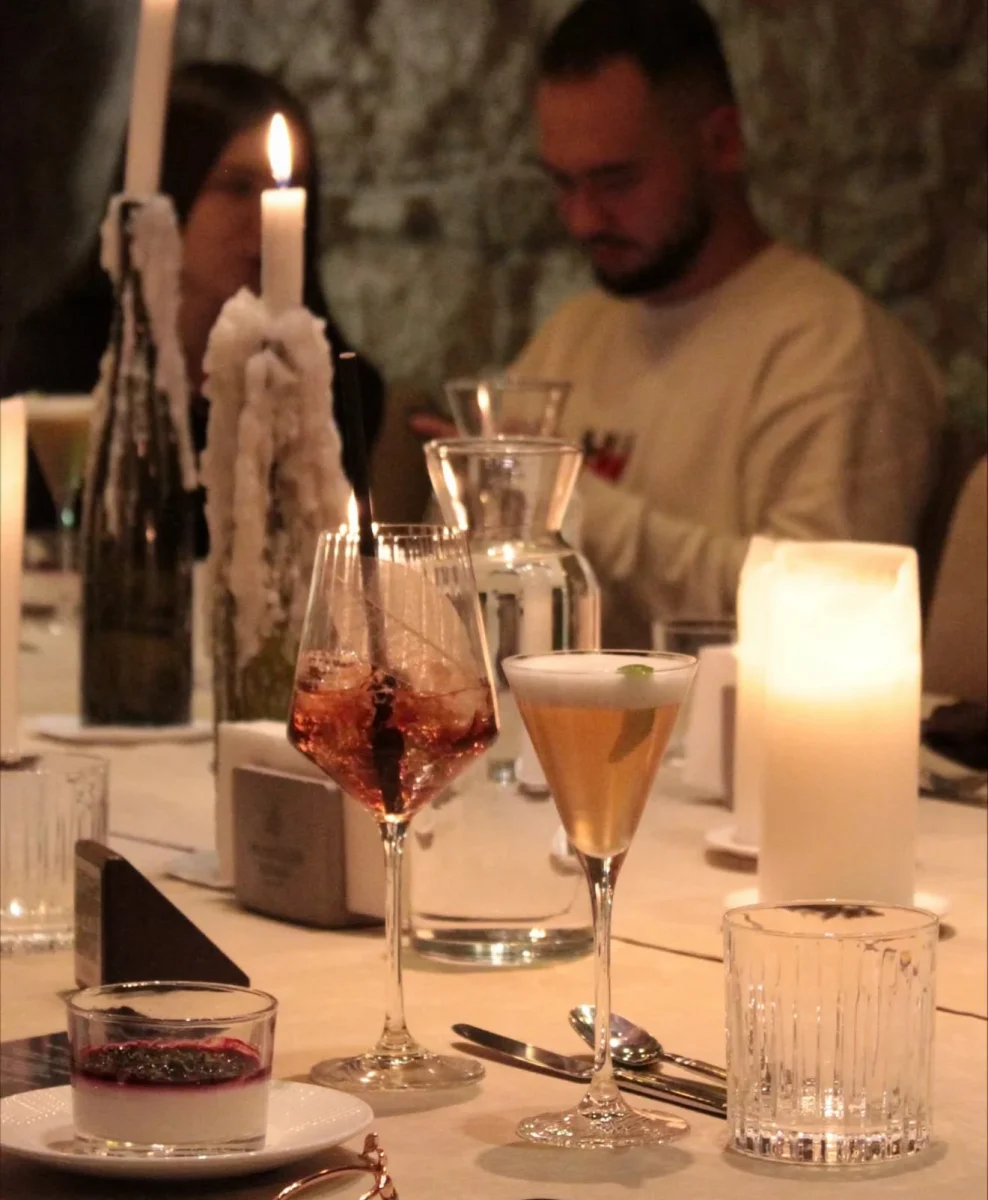 Cocktails and a dessert by candlelight with guests talking behind