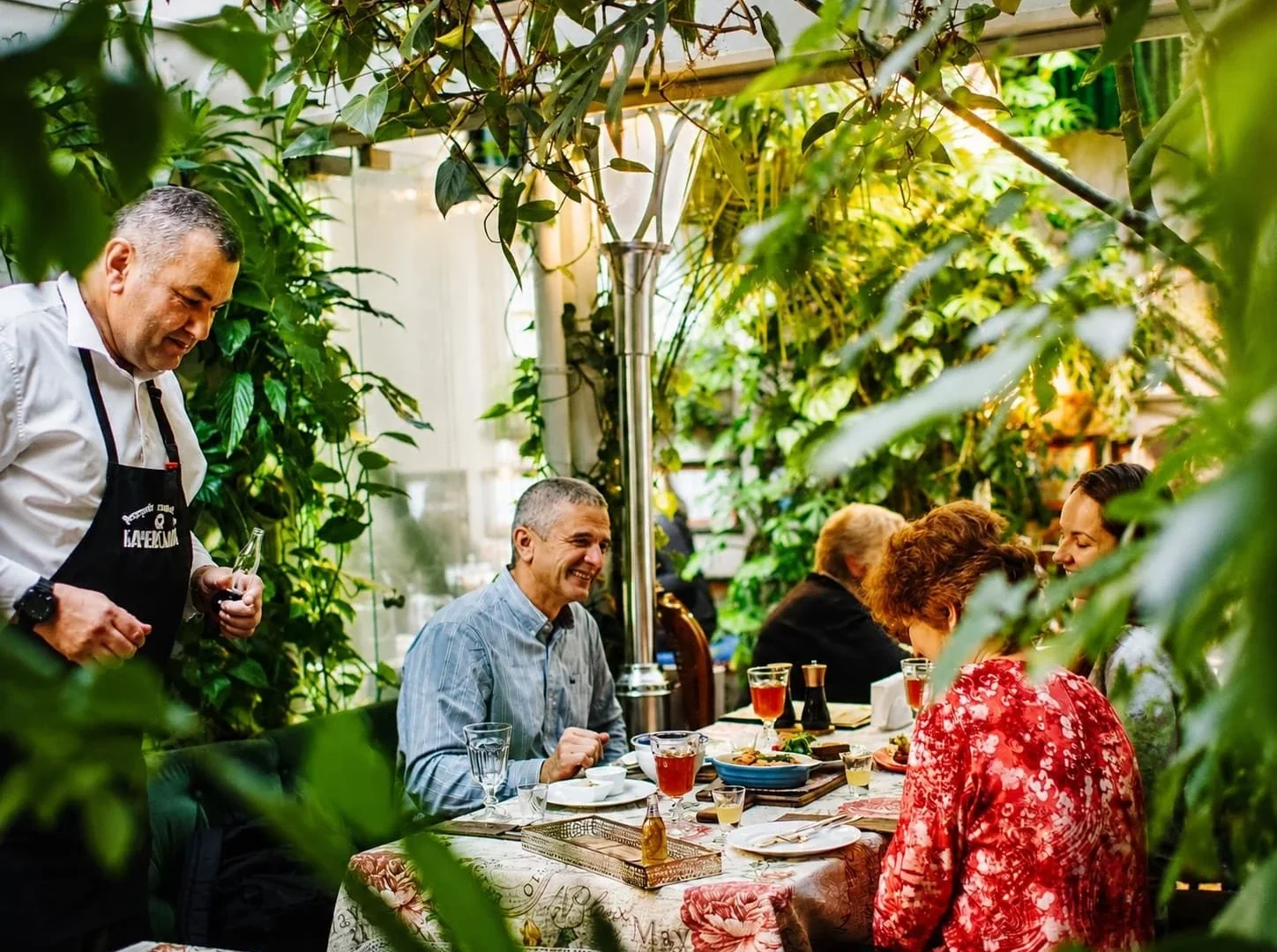 Guests having breakfast in the Orangery surrounded by greenery